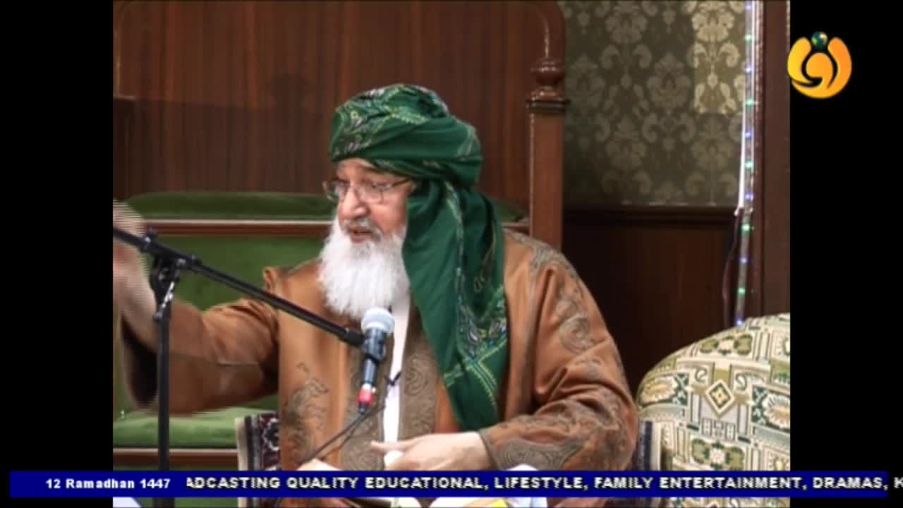 A man in a green turban and brown robe speaks into a microphone. The Noor TV logo is visible in the upper right corner.