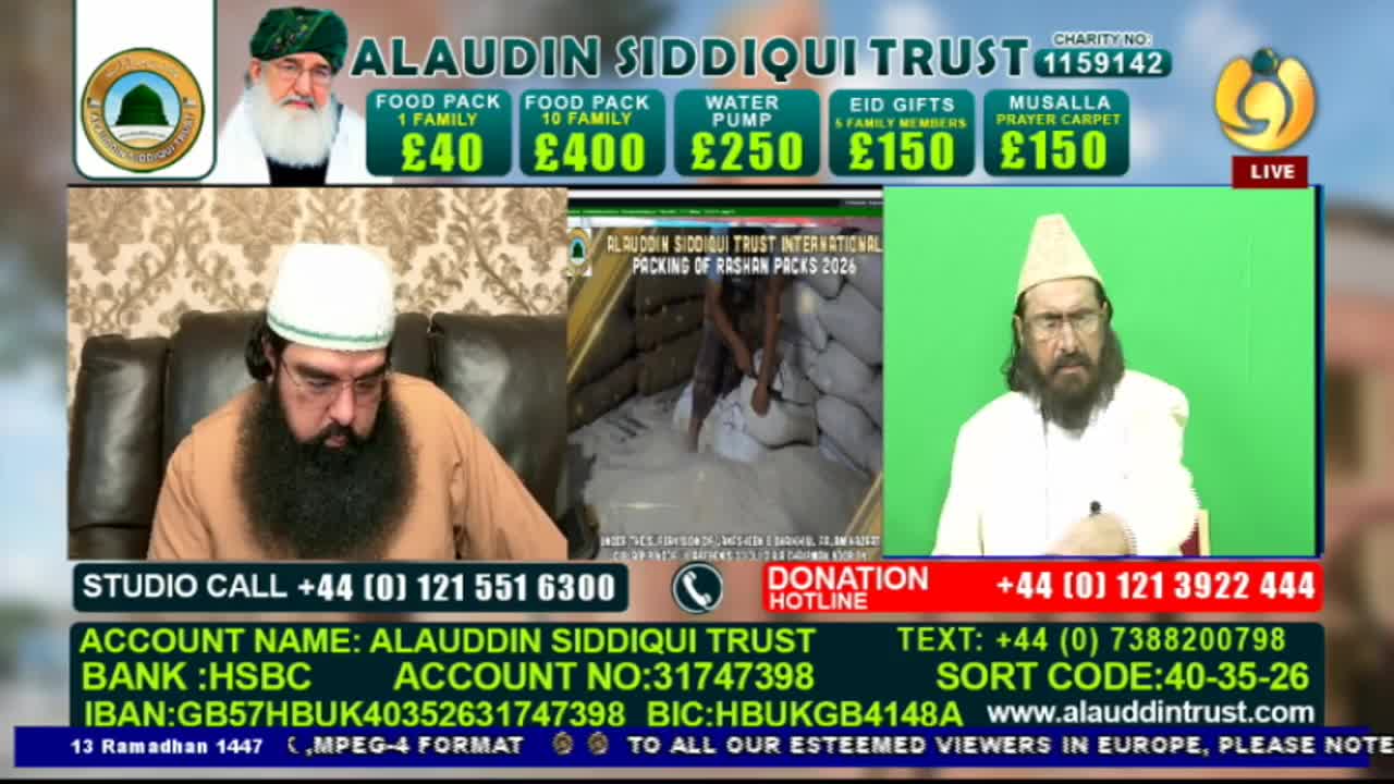 A man in a white cap and brown robe sits on a sofa, looking down. On a screen behind him, people are packing white sacks into a large pile. Another man, also wearing a white cap, speaks directly to the camera from a green backdrop.