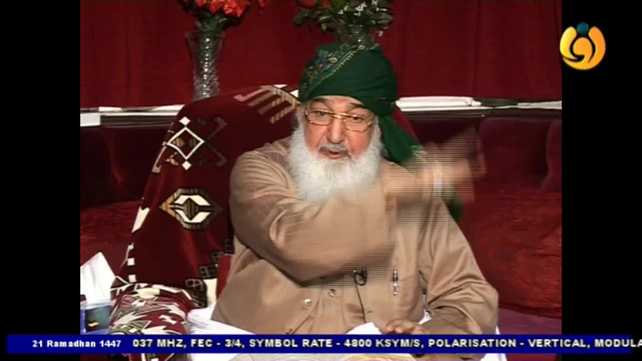 A man in a green turban gestures with his right hand while speaking. This broadcast, likely from Noor TV, is being transmitted from the UK.