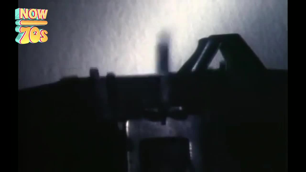 A typewriter's keys are being hammered, the letters appearing on the page. The silhouette of the hands and machine are stark against the bright paper.
