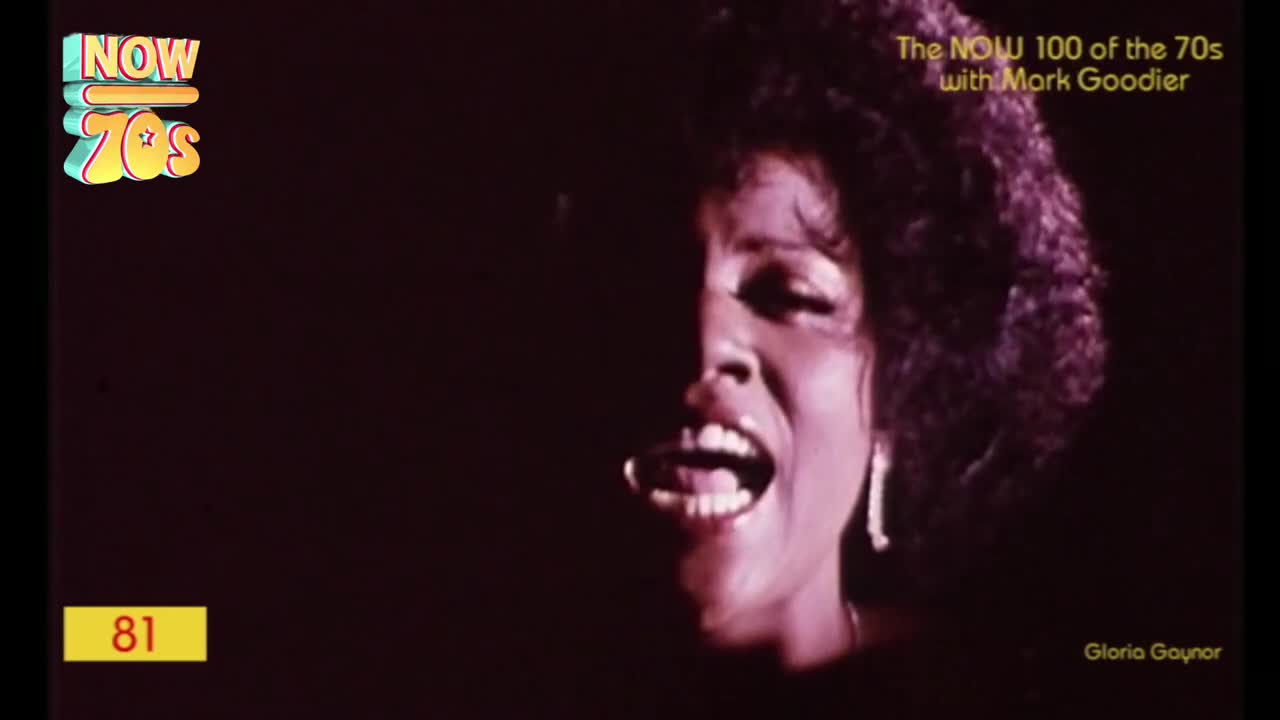 Gloria Gaynor's face is lit dramatically, her mouth wide open as she sings. The image is from a UK music show, a compilation of the 70s hits.
