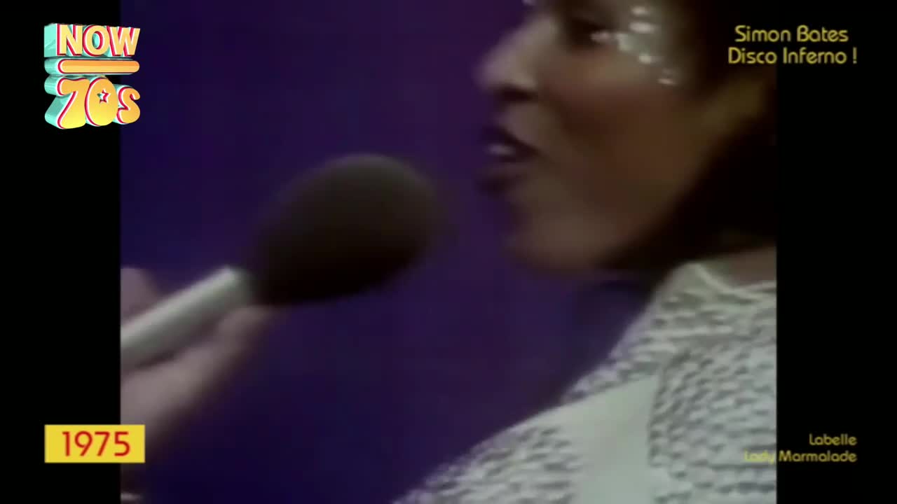 A woman with glitter on her face sings into a microphone, her mouth open. The stage lights reflect off her sequined outfit as she belts out the tune.
A woman with glitter on her face sings into a microphone, her mouth open. The stage lights reflect off her sequined outfit as she belts out the tune.