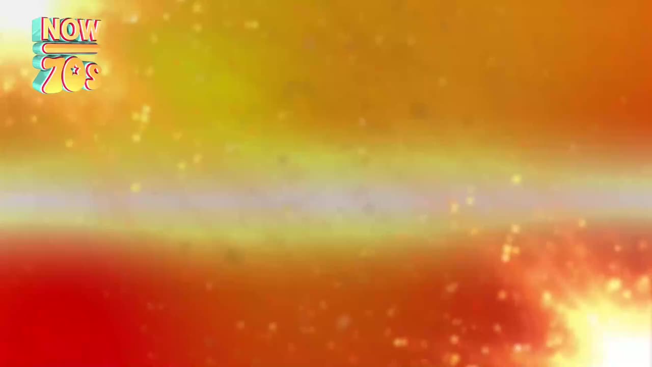 The "NOW 70s" logo floats in the top left, a 3D effect against a gradient of orange and yellow. Tiny, bright specks of light dance across the screen.
