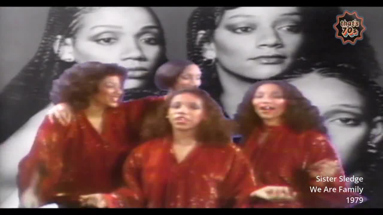 Four women in shimmering red outfits stand together, their faces lit by the stage lights. Behind them, large black and white portraits of other women with braided hair loom.
