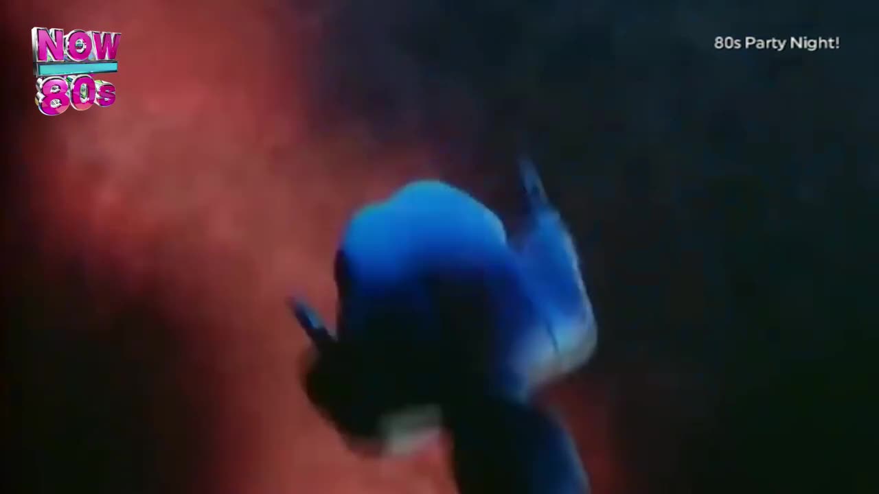 A figure in blue is silhouetted against a red backdrop, arms raised in a dance move. The "Now 80s" logo sits in the corner, promising a night of music.
