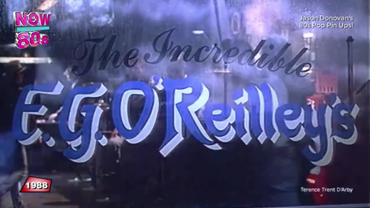 The window of "E.G. O'Reilly's" is visible, with its blue and white lettering. Through the glass, figures move dimly, and the "Now 80s" logo sits in the corner.

