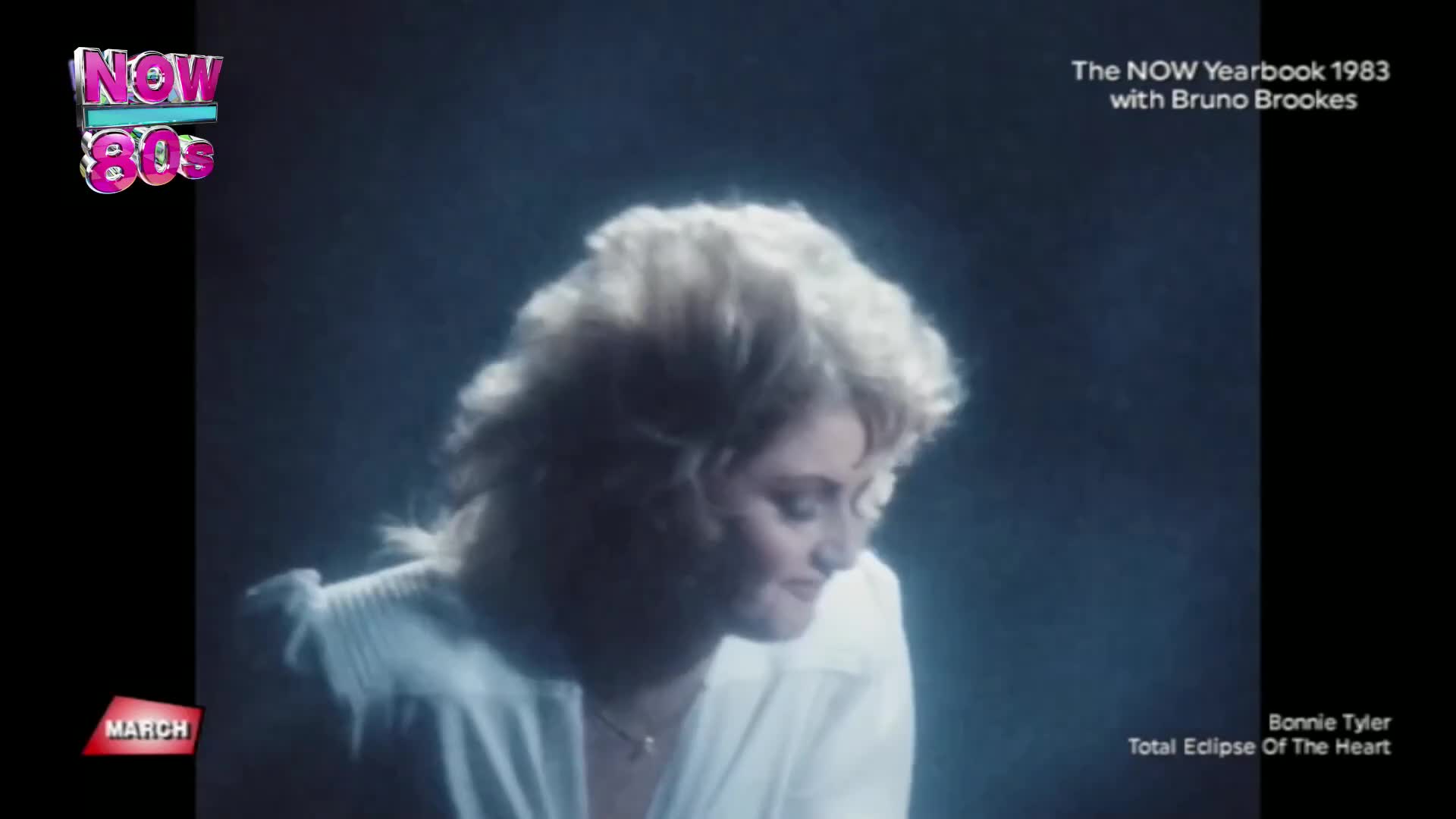Bonnie Tyler's blonde hair catches the light as she looks down, a soft smile on her face. The "NOW 80s" logo glows in the corner, hinting at a classic hit from 1983.