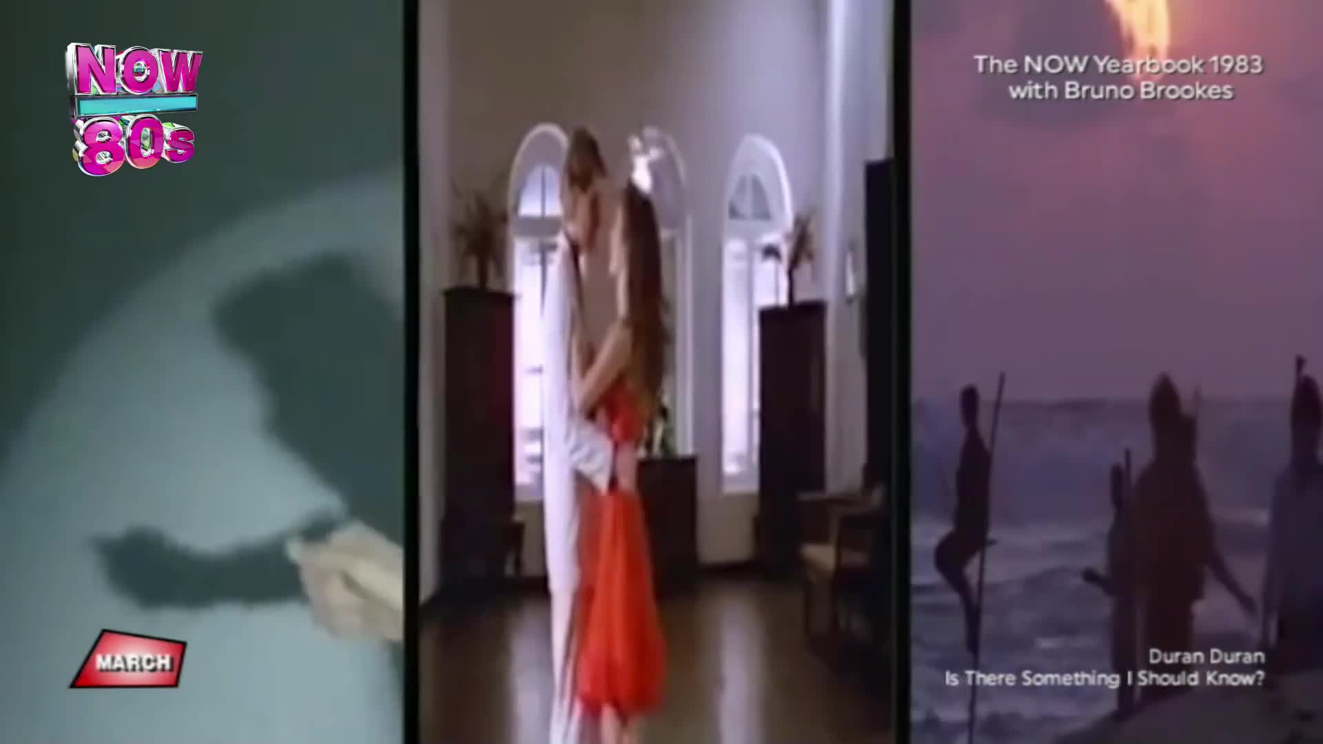 A couple embraces in a sunlit hallway. On the right, silhouetted figures stand on stilts in the ocean as waves crash.