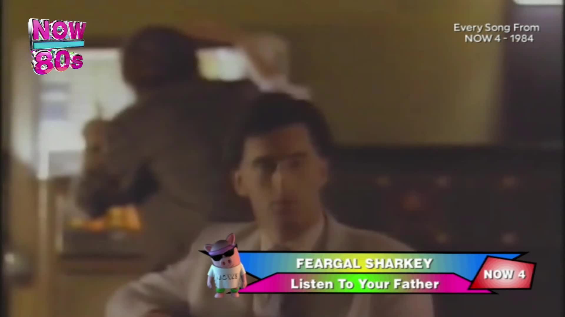 A man in a light suit stands in front of a dark background, his face partially obscured by glasses. A cartoon pig wearing sunglasses and a t-shirt bounces near a colourful graphic displaying "FEARGAL SHARKEY" and "Listen To Your Father."