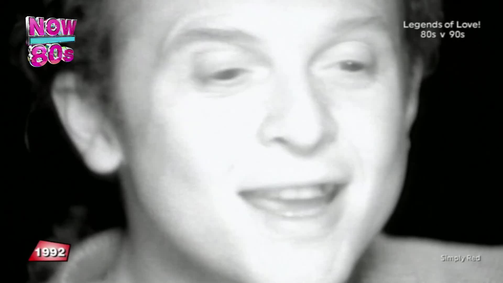 A man's face fills the screen, his mouth open as if singing. The "Now 80s" logo flashes in the corner, and the year 1992 appears below.