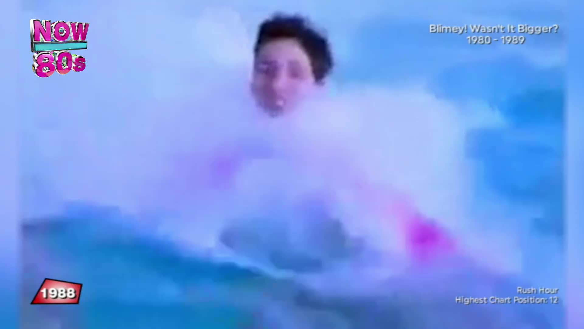 A young man's face emerges from swirling pink and blue mist. This clip is from 1988, a year that saw "Rush Hour" reach number 12 on the charts.