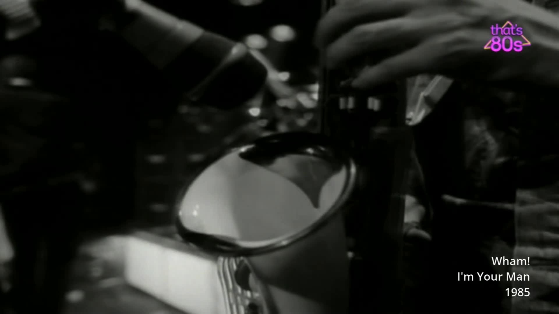 A microphone is positioned over a shiny, white object that looks like a bucket. Hands are visible, adjusting something out of frame. A microphone is positioned over a shiny, white object that looks like a bucket. Hands are visible, adjusting something out of frame.