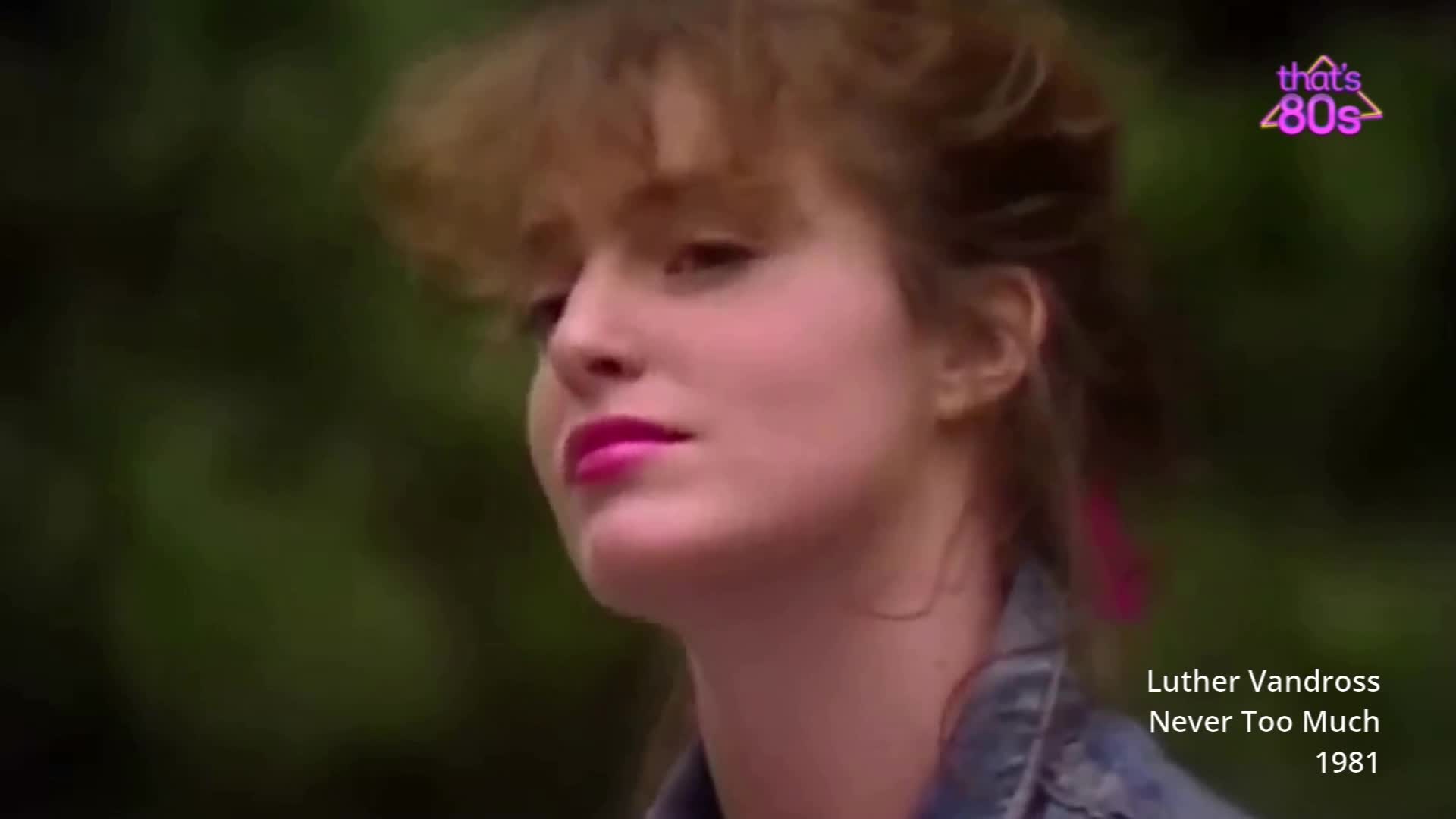 A young woman with bright pink lipstick looks off to the side, her hair a bit windswept. A neon pink ribbon is tied in her hair, catching the light.