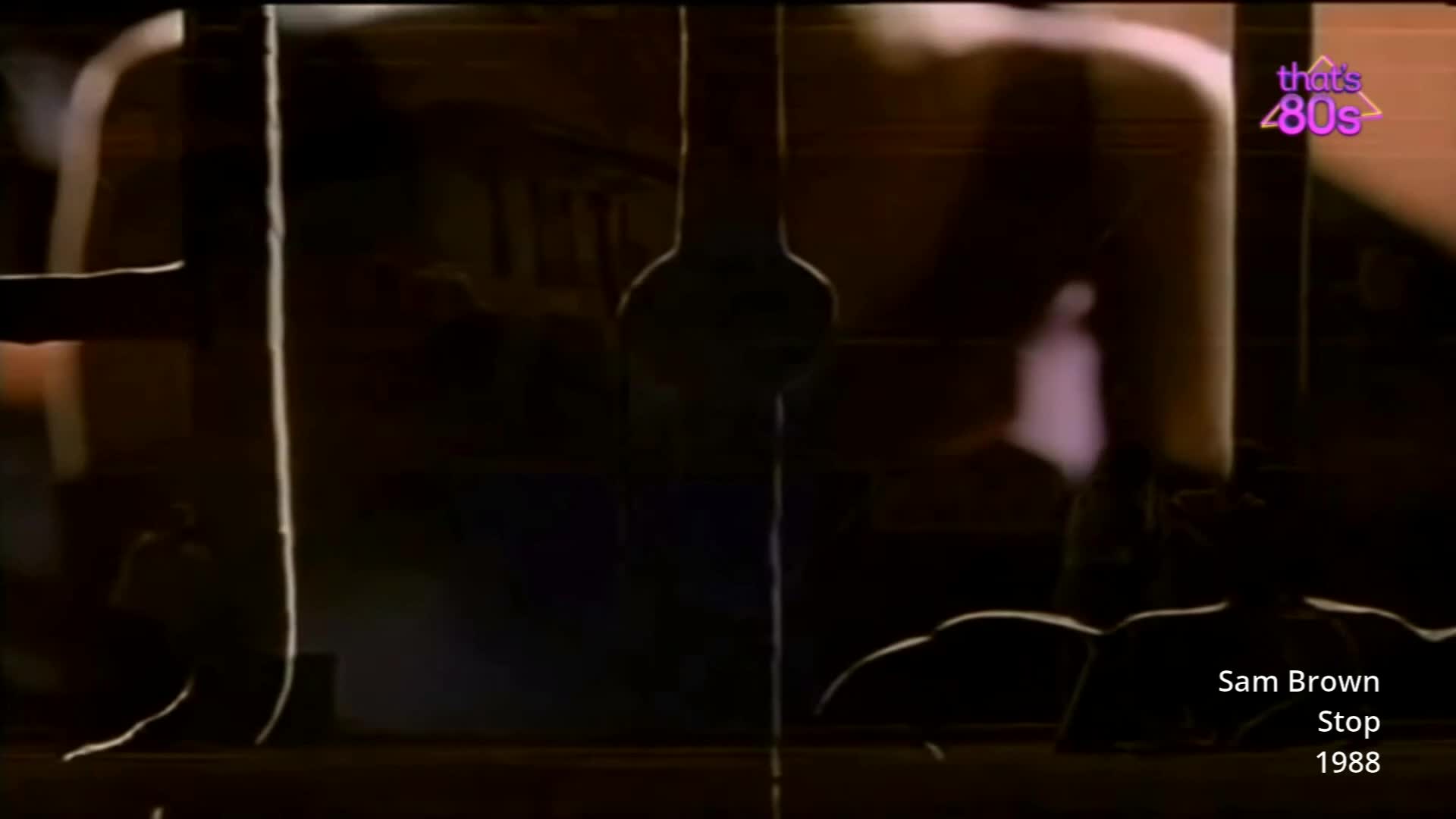 A figure stands silhouetted against a bright light. The scene is dark, with a hint of purple light reflecting on a surface.