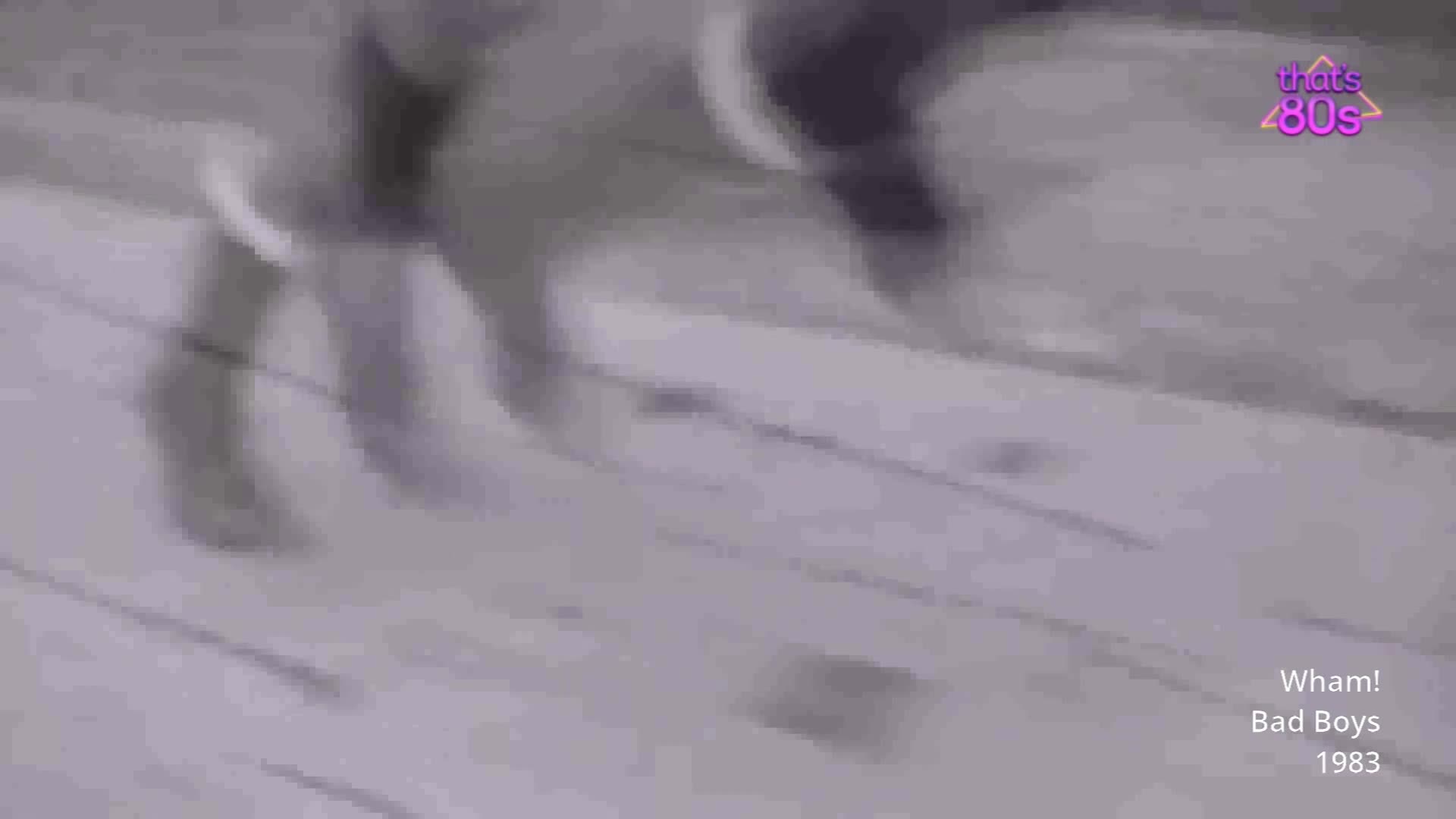 A figure in a dark top and light trousers moves quickly across a wooden floor. The movement is so fast, the legs are a blur.