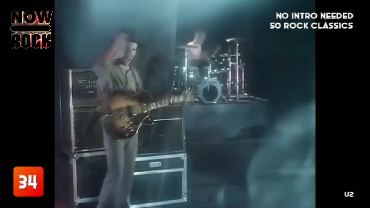 The guitarist, in a light-colored suit, is leaning into the microphone, playing a hollow-body guitar. Behind him, the drummer is a shadowy figure, keeping the beat on the kit.
