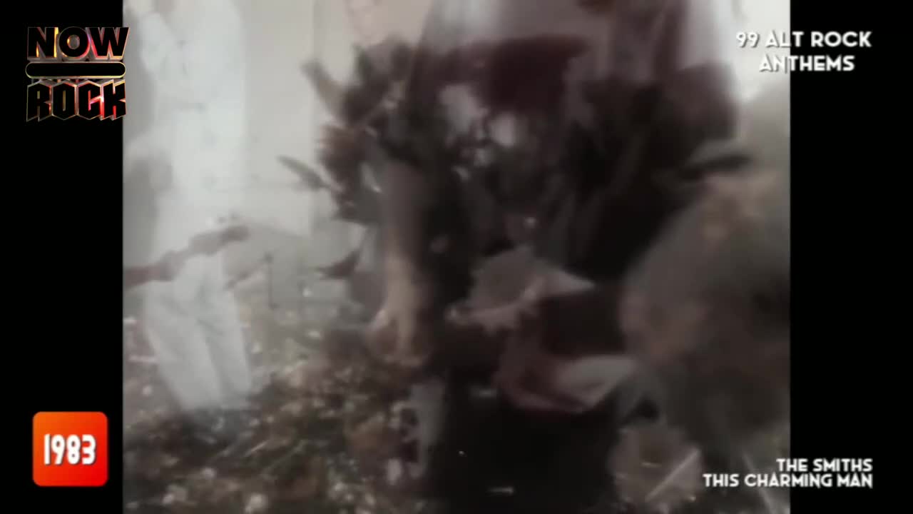 The band is obscured by a mass of flowers, but the singer in a white shirt is visible. It's a performance of "This Charming Man" from The Smiths, a classic UK song.
