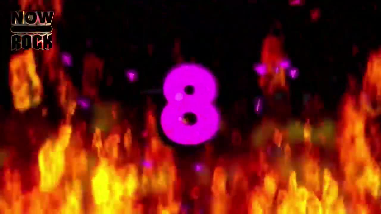 A bright pink number eight glows against a backdrop of flickering flames. Floating purple sparks drift across the dark background, and the "NOW ROCK" logo is visible at the top left.
