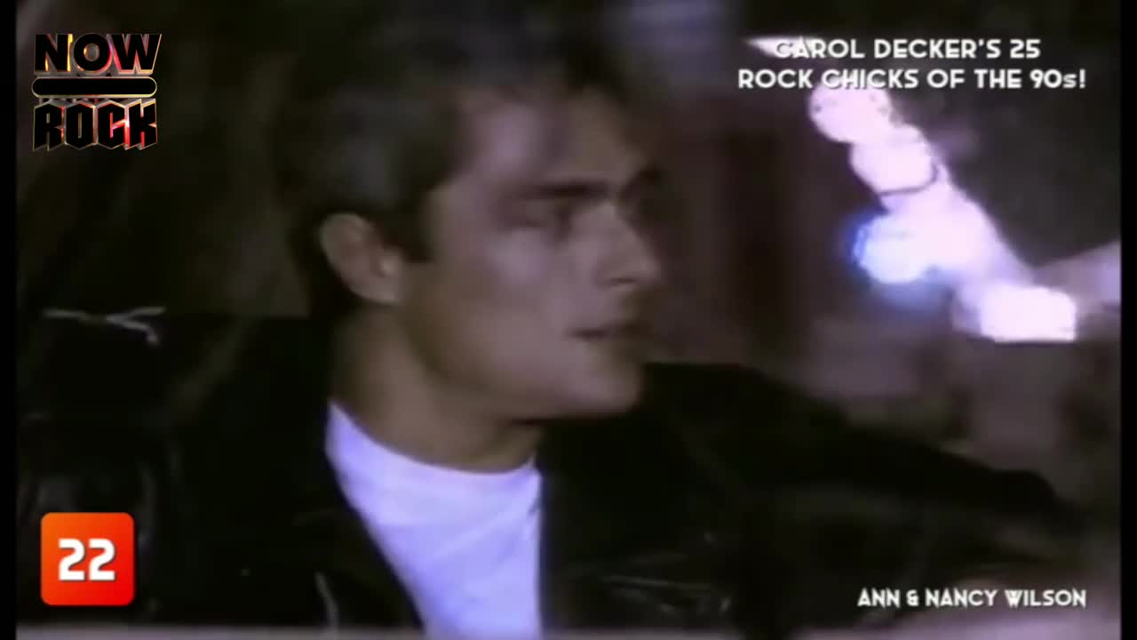 A man in a leather jacket looks off to the side, his face illuminated by a soft light. The "NOW Rock" logo and a countdown number are in the corner, suggesting the show is on.
