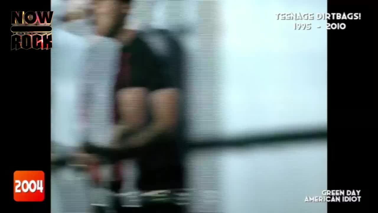 The camera is shaking, following figures moving quickly to the left. It's a clip from a music video, playing on the NOW Rock channel.
