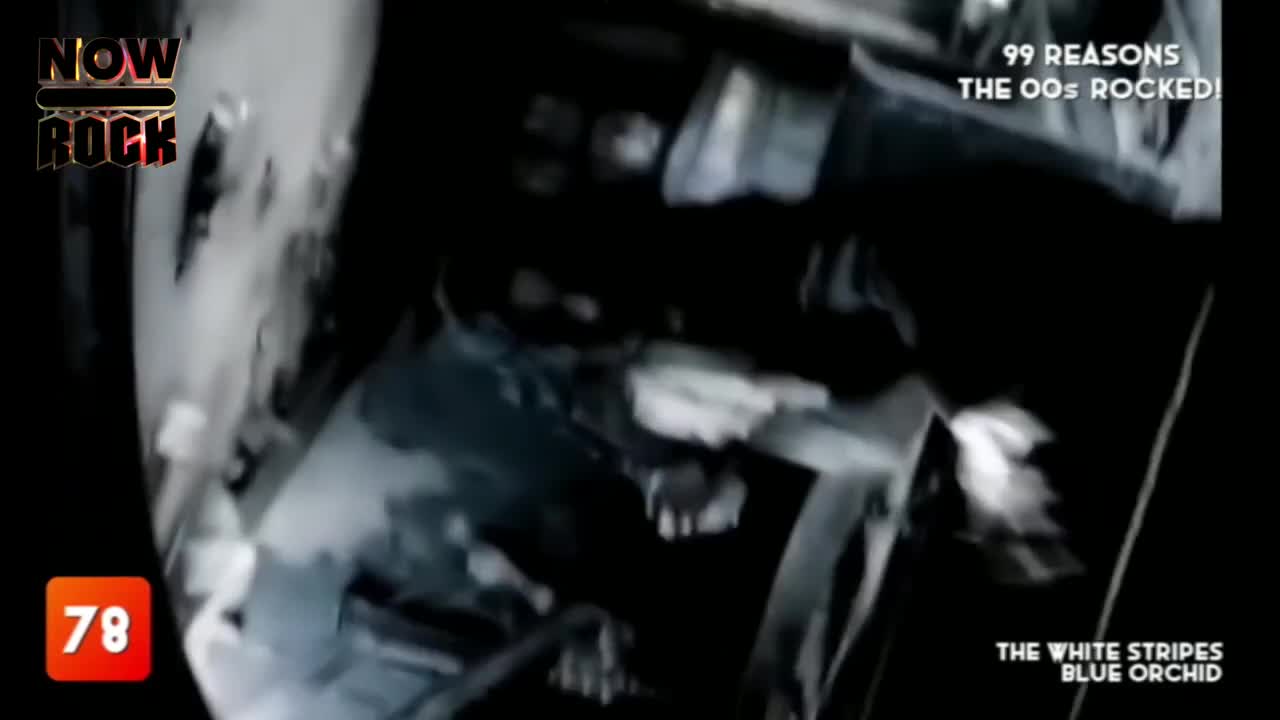 The NOW Rock logo sits in the corner as a faded, distorted figure moves in a dark, grainy clip.  The White Stripes' "Blue Orchid" is playing, and the video is a black and white, with a blurry effect.

