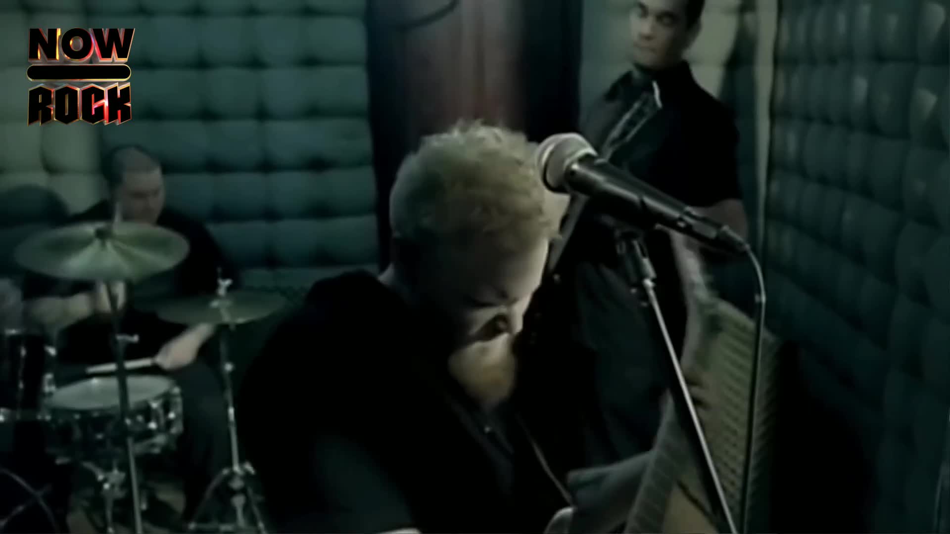 The singer, with a full beard, is hunched over a keyboard, playing. Behind him, the drummer hits the snare, and another band member stands ready, microphone in hand.
The singer, with a full beard, is hunched over a keyboard, playing. Behind him, the drummer hits the snare, and another band member stands ready, microphone in hand.