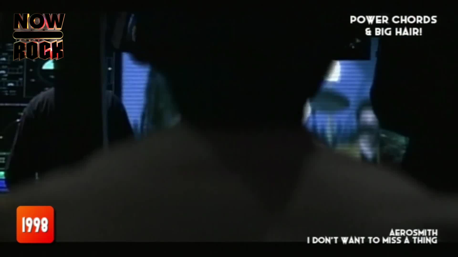Aerosmith's "I Don't Want to Miss a Thing" plays as a band member's silhouette moves behind a drum kit. The "NOW Rock" logo and "1998" flash in the corner, indicating a UK broadcast.