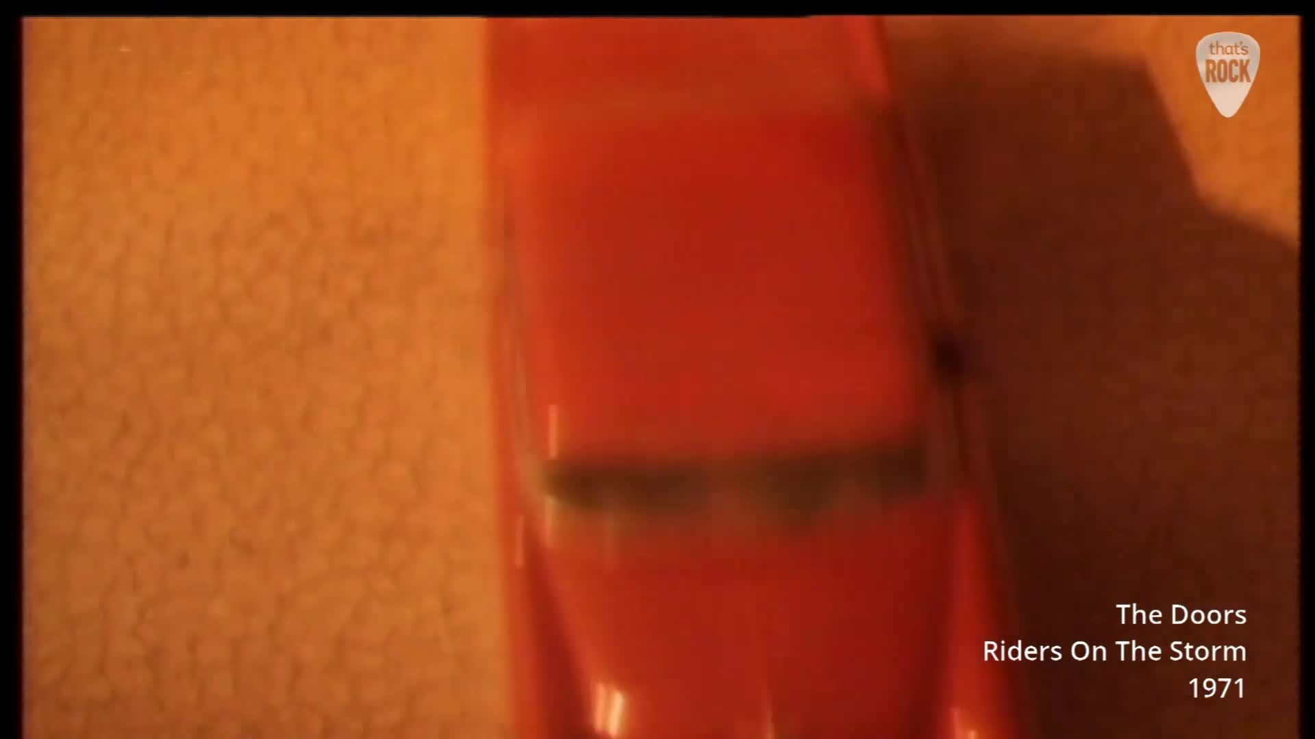 A bright red toy car glides across a textured orange surface. The car's windows are blurred, suggesting its movement. A bright red toy car glides across a textured orange surface. The car's windows are blurred, suggesting its movement.