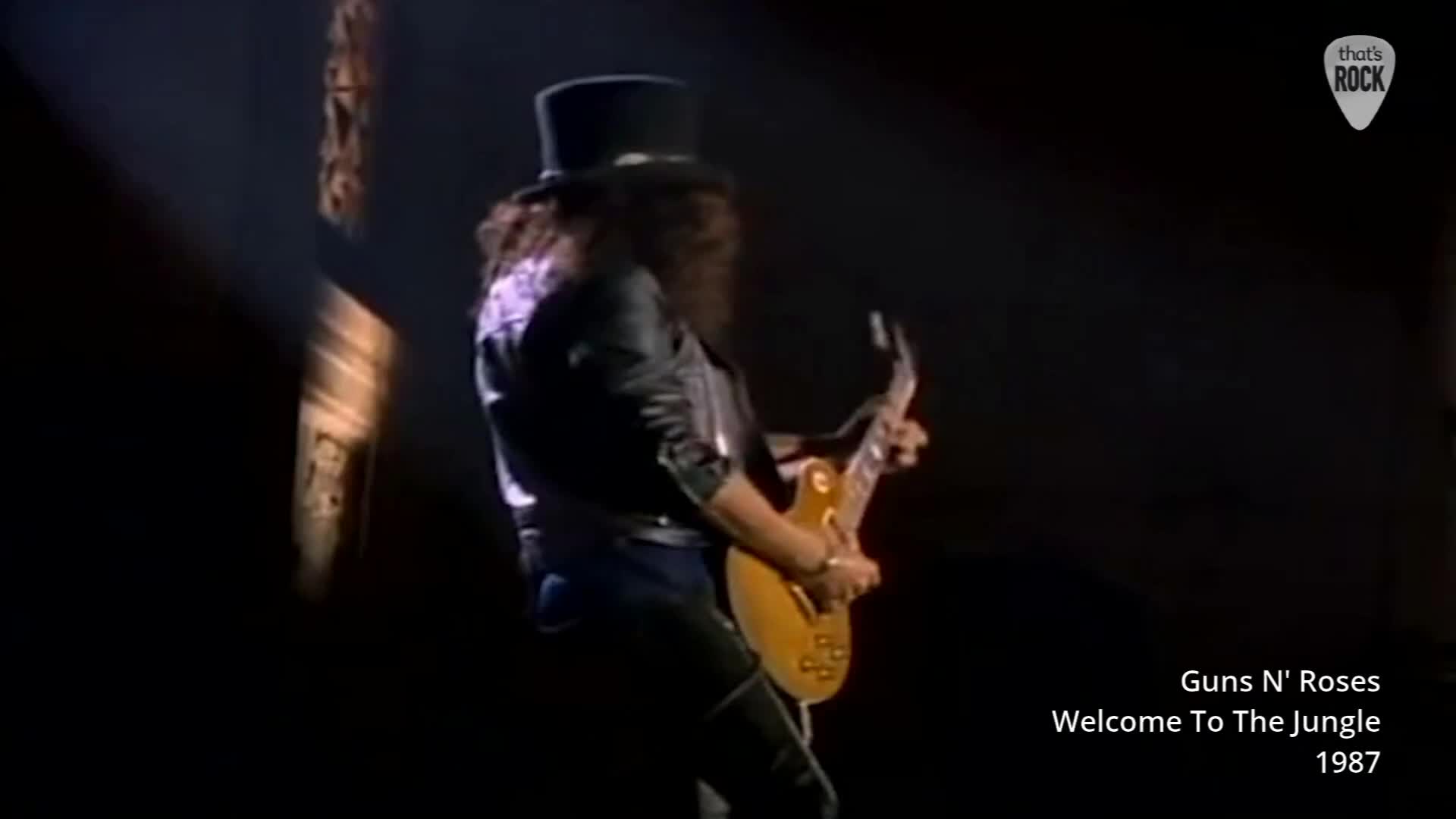 A guitarist in a top hat and leather jacket plays a sunburst Les Paul, bathed in a single spotlight. The crowd roars as he launches into "Welcome to the Jungle." A guitarist in a top hat and leather jacket plays a sunburst Les Paul, bathed in a single spotlight. The crowd roars as he launches into "Welcome to the Jungle."