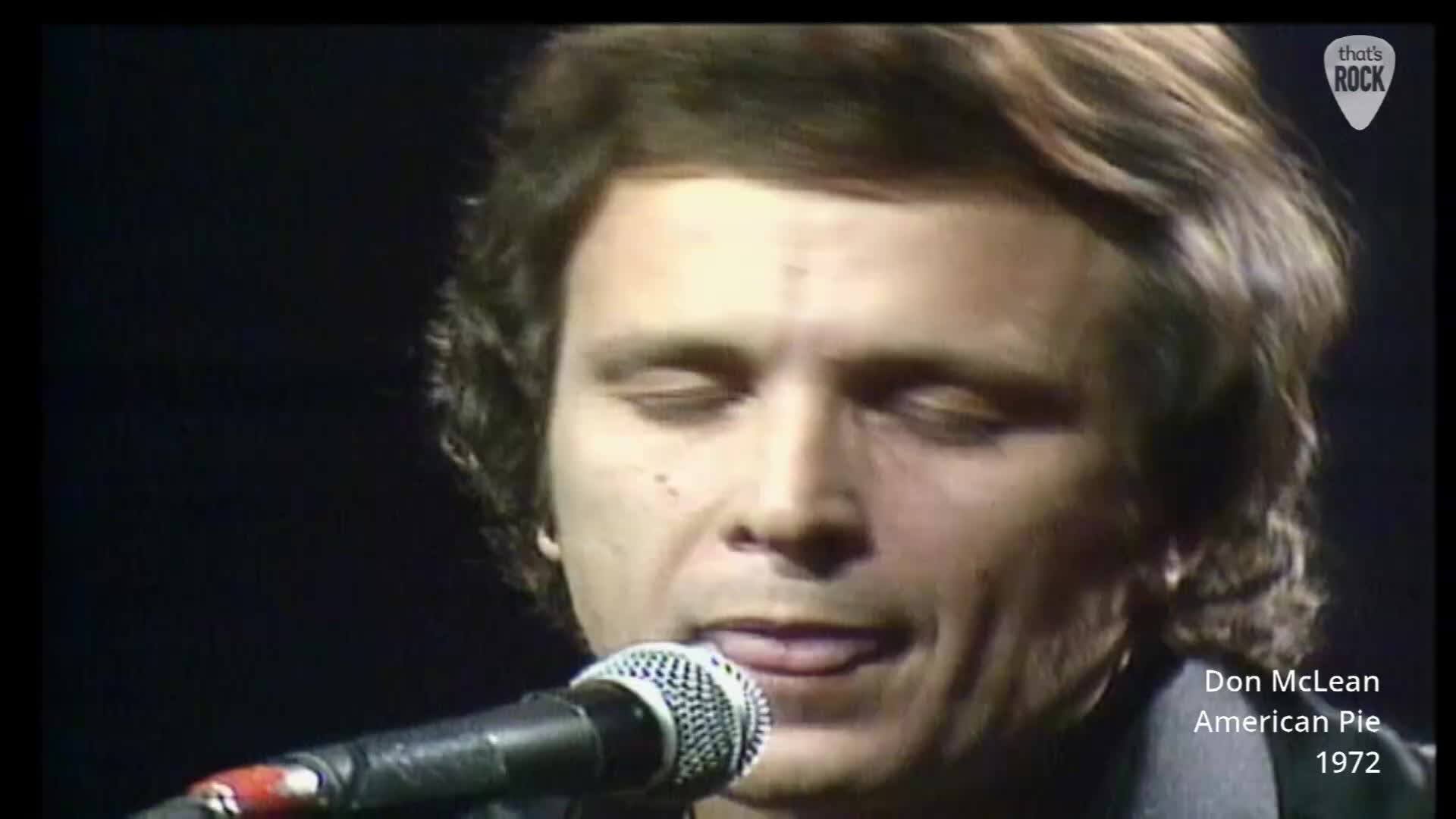 Don McLean's eyes are closed as he sings into the microphone. His tongue peeks out slightly as he delivers the lyrics. Don McLean's eyes are closed as he sings into the microphone. His tongue peeks out slightly as he delivers the lyrics.