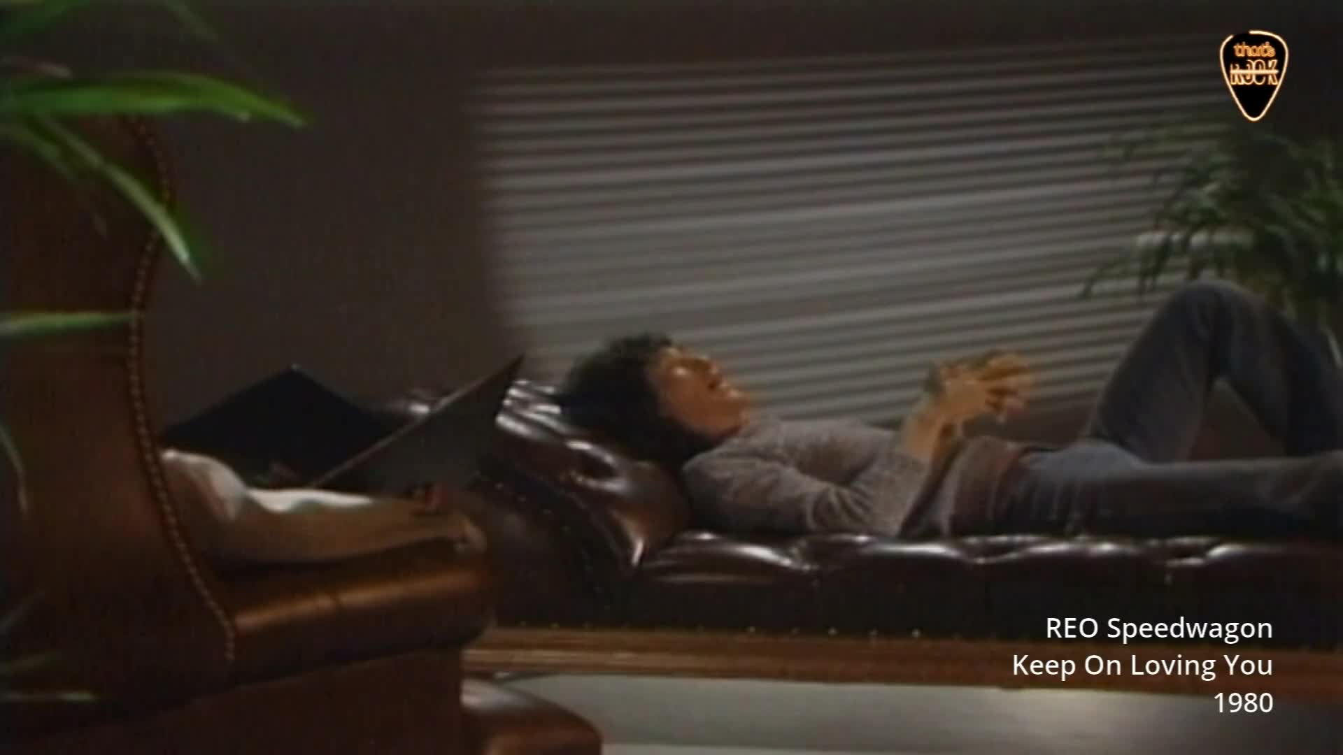 A man reclines on a brown leather sofa, his head tilted back. He's wearing a grey sweater and dark trousers. A man reclines on a brown leather sofa, his head tilted back. He's wearing a grey sweater and dark trousers.