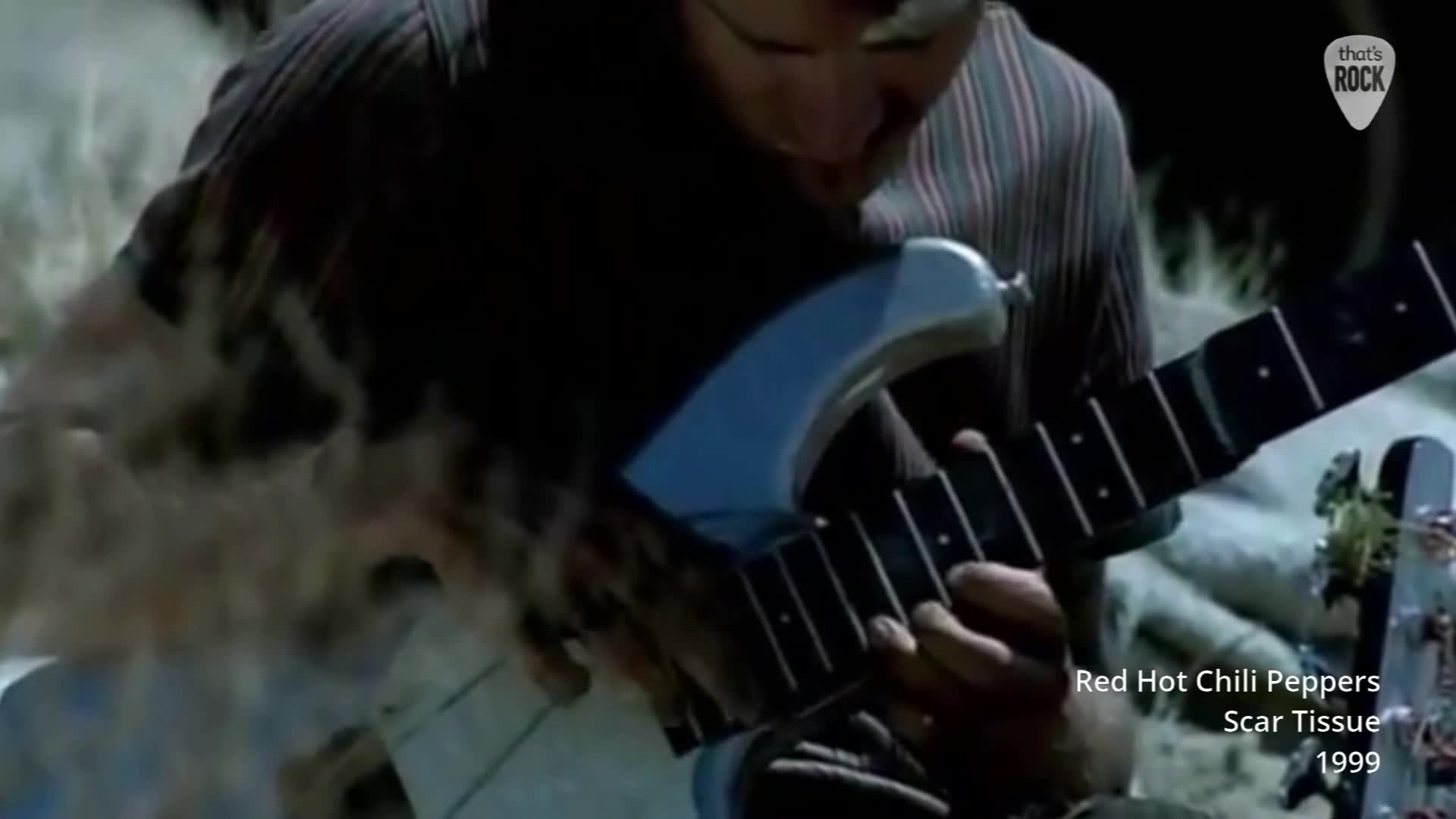 A guitarist's hands move across the fretboard of a light blue electric guitar. Wisps of smoke curl around the instrument as he plays. A guitarist's hands move across the fretboard of a light blue electric guitar. Wisps of smoke curl around the instrument as he plays.