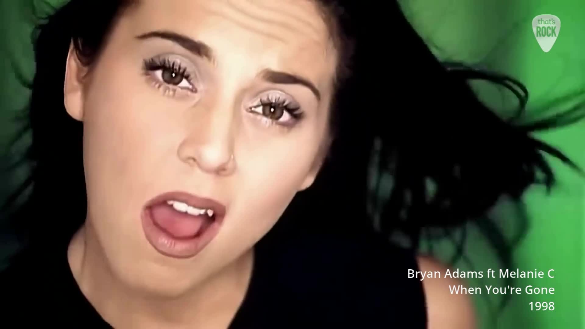 Melanie C's dark hair whips around her face as she sings into the microphone. The bright green background pulses with energy, a fitting backdrop for this 1998 hit from the UK.