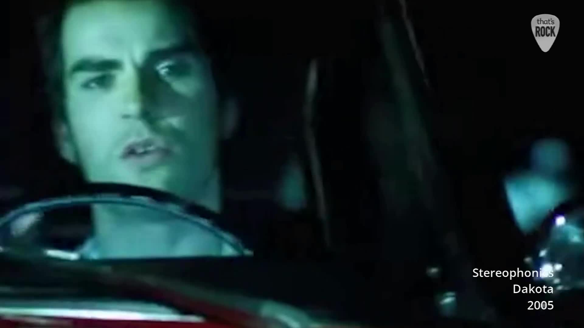 Kelly Jones is driving at night, his face illuminated by the dashboard lights. The car's interior is dark, with only the glow of the instruments and the occasional passing light visible.