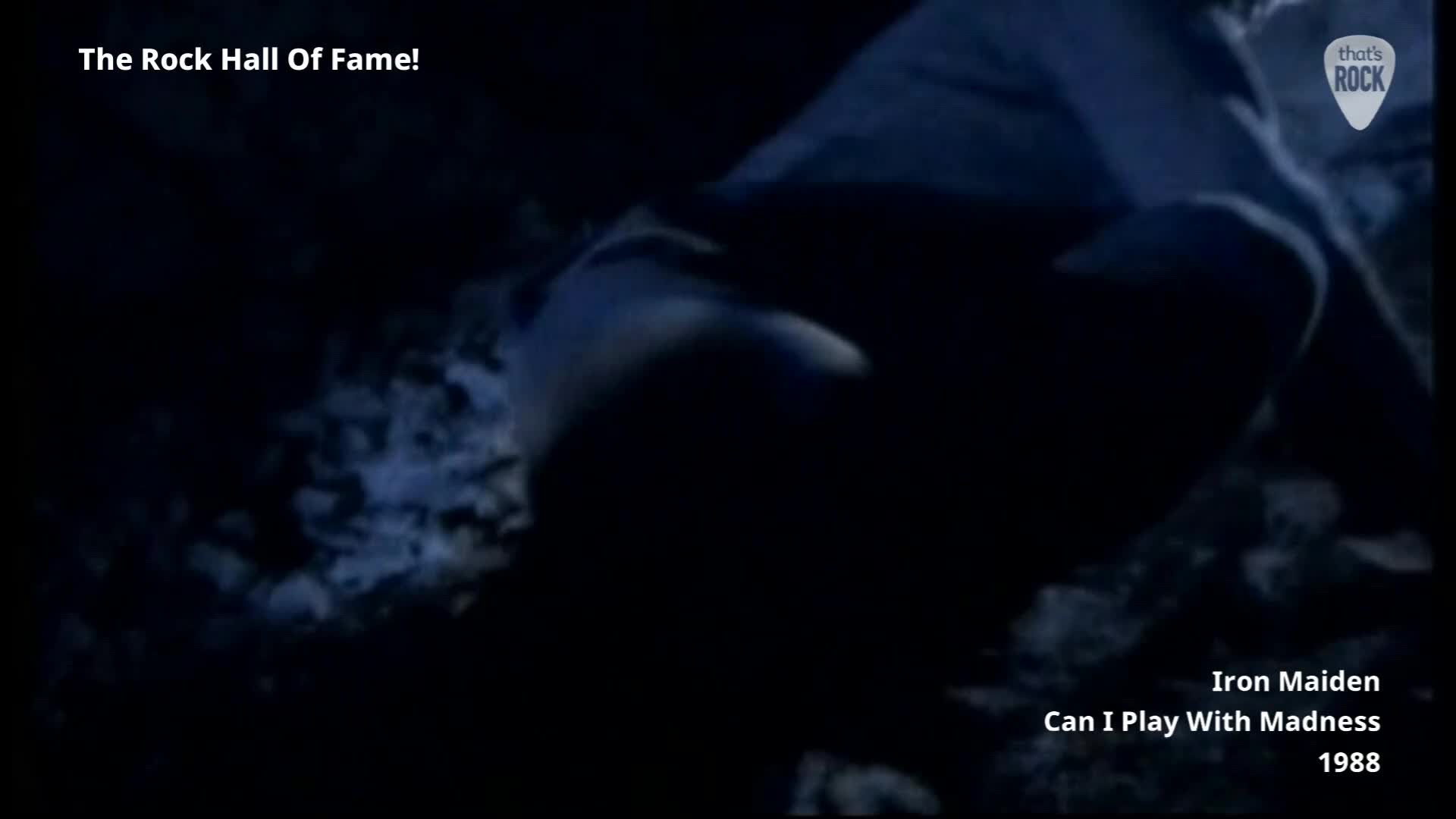 A figure crouches low in the darkness, their form indistinct. The ground beneath them is a chaotic mix of shadows and light.