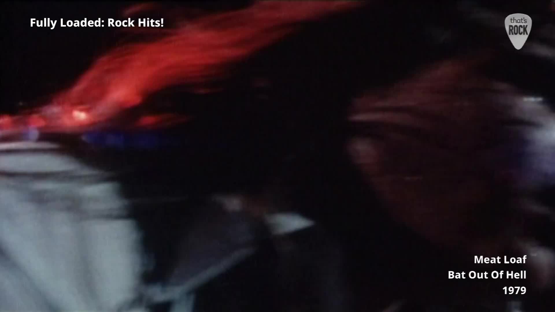 A cascade of fiery red light washes over a dark, indistinct shape that's moving rapidly. The air is thick with the raw energy of a performance, the kind that defined rock music in the UK back in '79.