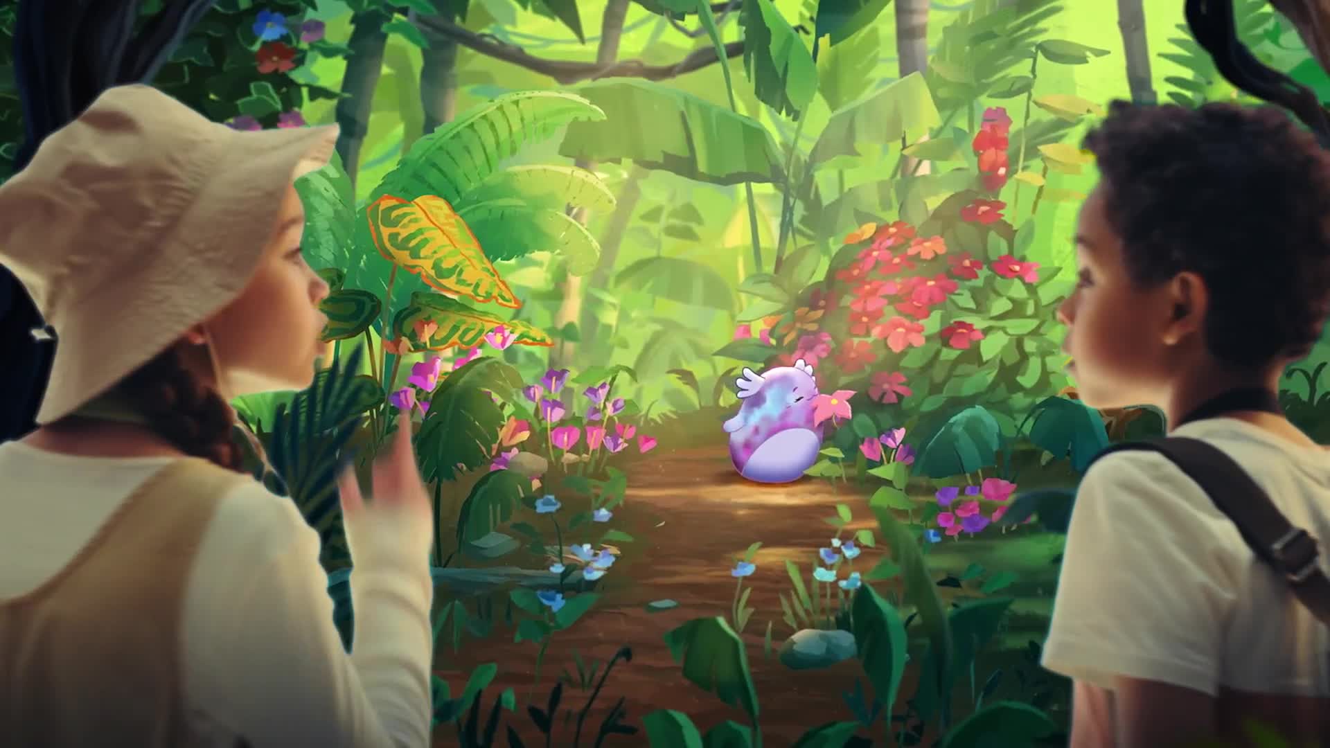 Two children gaze at a small, round creature with wings, resting on a path through a lush, colorful jungle. Sunlight filters through the leaves, illuminating the vibrant flowers and foliage around them.
