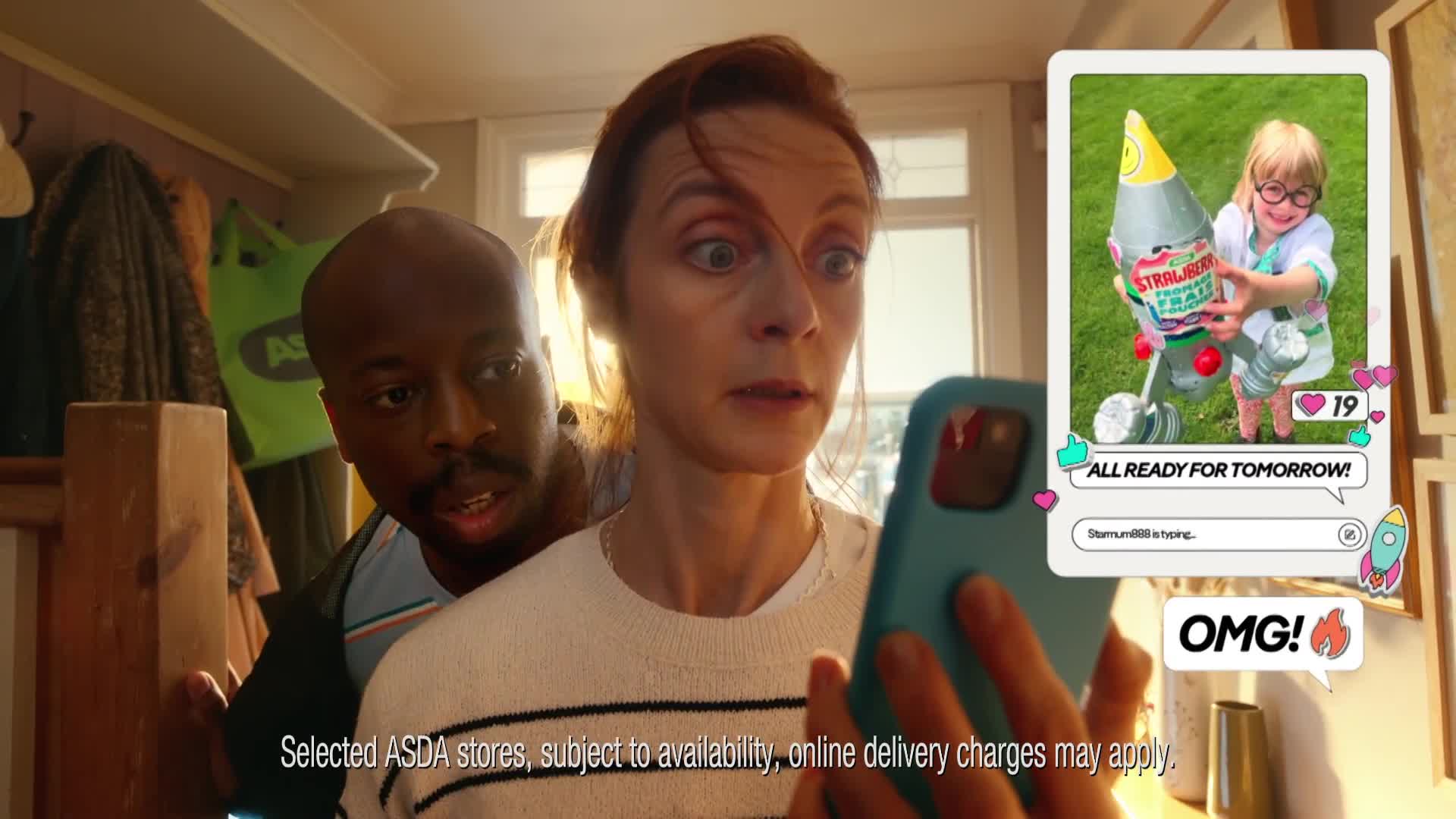 A woman stares wide-eyed at her phone, while a man peers over her shoulder, his expression mirroring her surprise. On the screen, a child holds a novelty rocket, the image overlaid with social media-style graphics.
