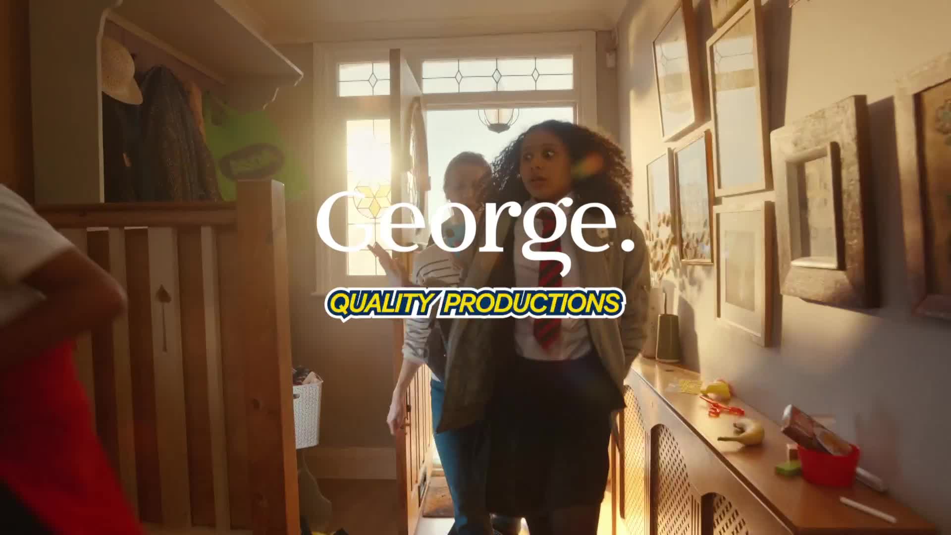 A young woman in a school uniform, tie askew, looks surprised as she enters a brightly lit hallway. Behind her, another person gestures, and the doorway frames a sunny, UK-style day.
