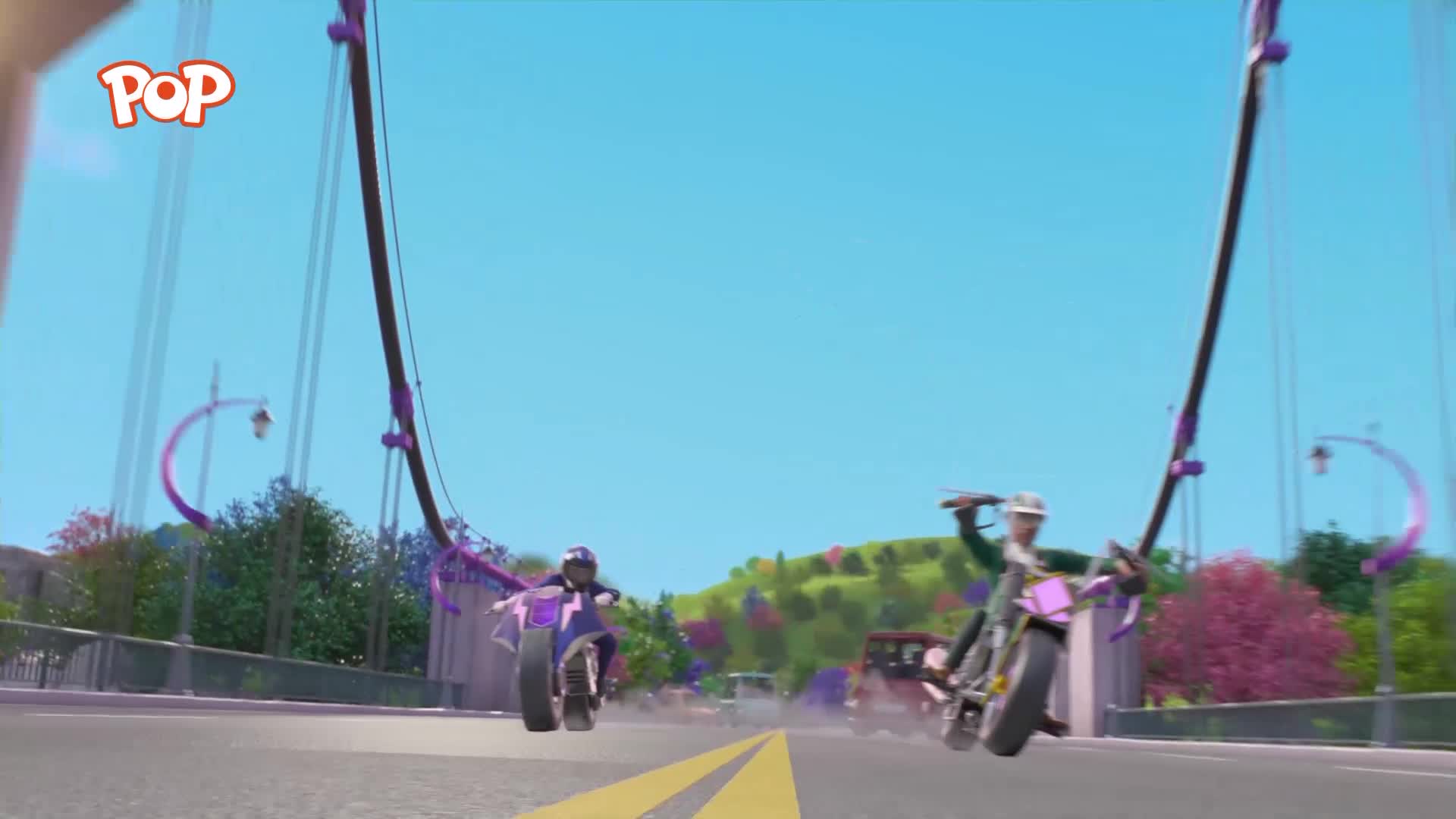 Two motorbikes race across a bridge, their wheels kicking up dust. The one on the right is leaning into a turn, its rider looking back.