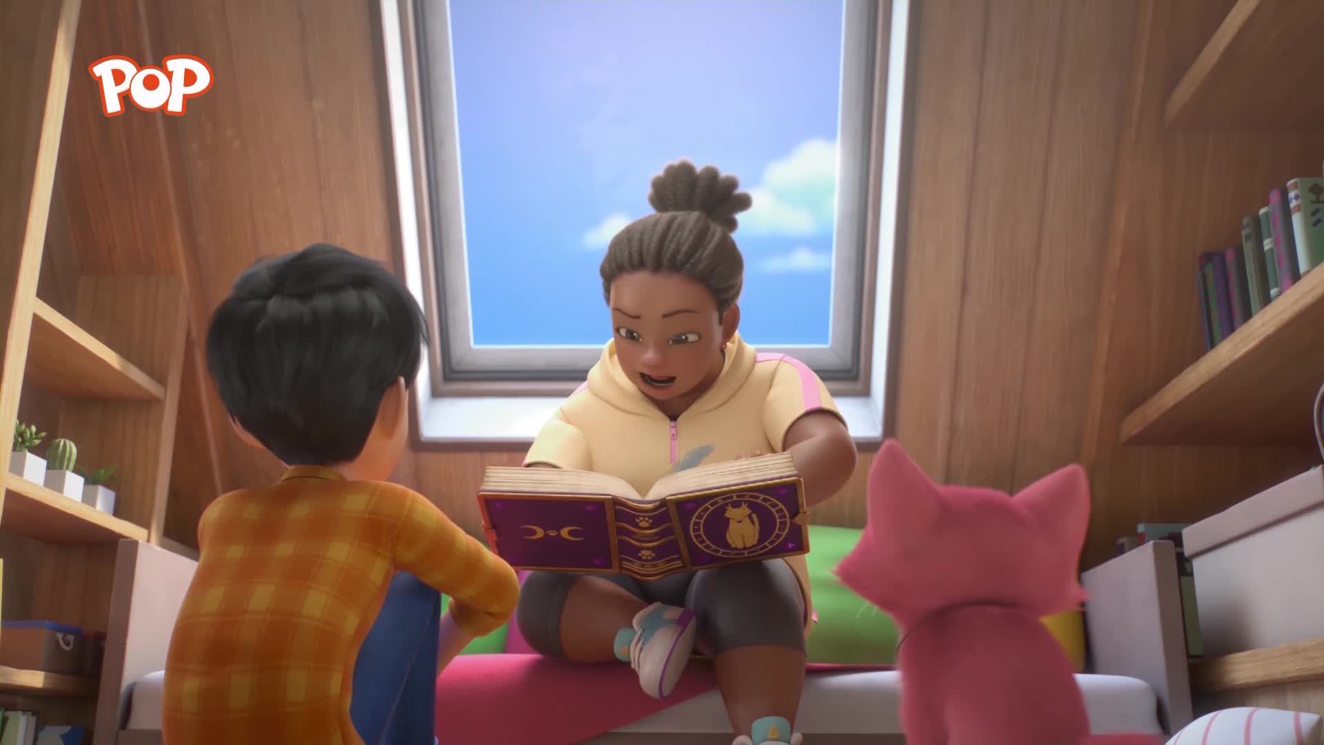 A girl in a yellow hoodie reads from an ornate book to a boy in an orange plaid shirt. A bright pink cat sits attentively beside them.