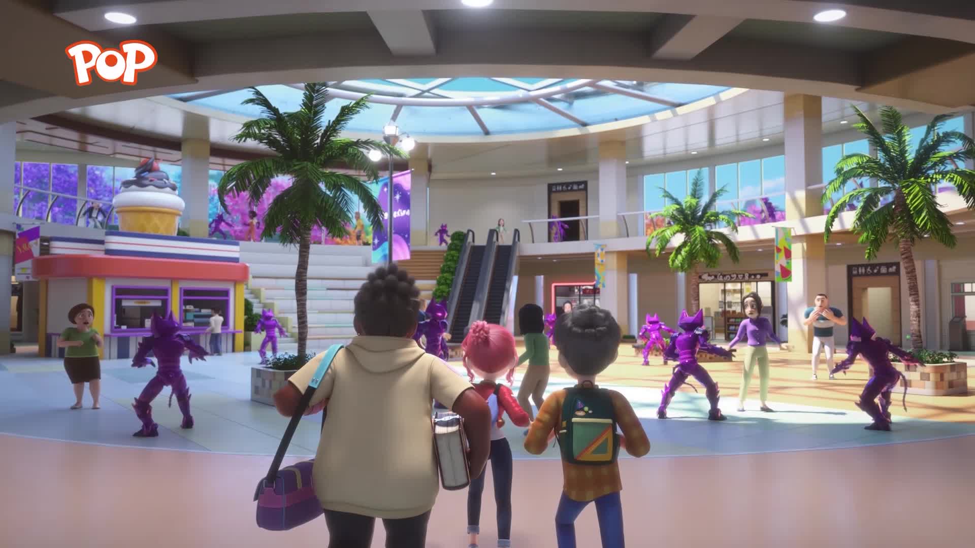 A group of purple creatures are dancing around a woman in a shopping centre. A few kids are watching them from behind.