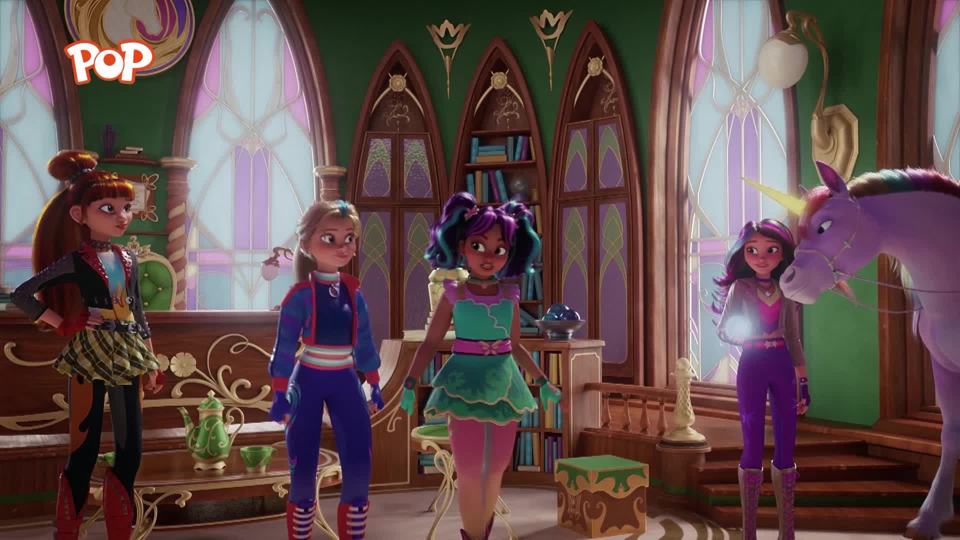 Four girls stand in a room with tall, arched windows, a purple unicorn beside them. One girl, in a bright green dress, holds a glowing orb.