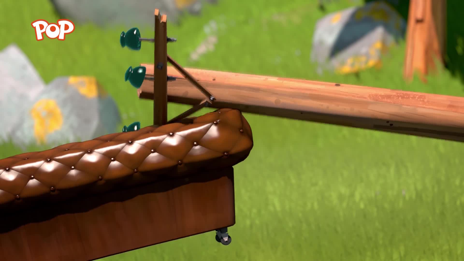 A brown, tufted sofa with wheels rolls along a wooden track. The POP logo floats above a grassy field with rocks. A brown, tufted sofa with wheels rolls along a wooden track. The POP logo floats above a grassy field with rocks.