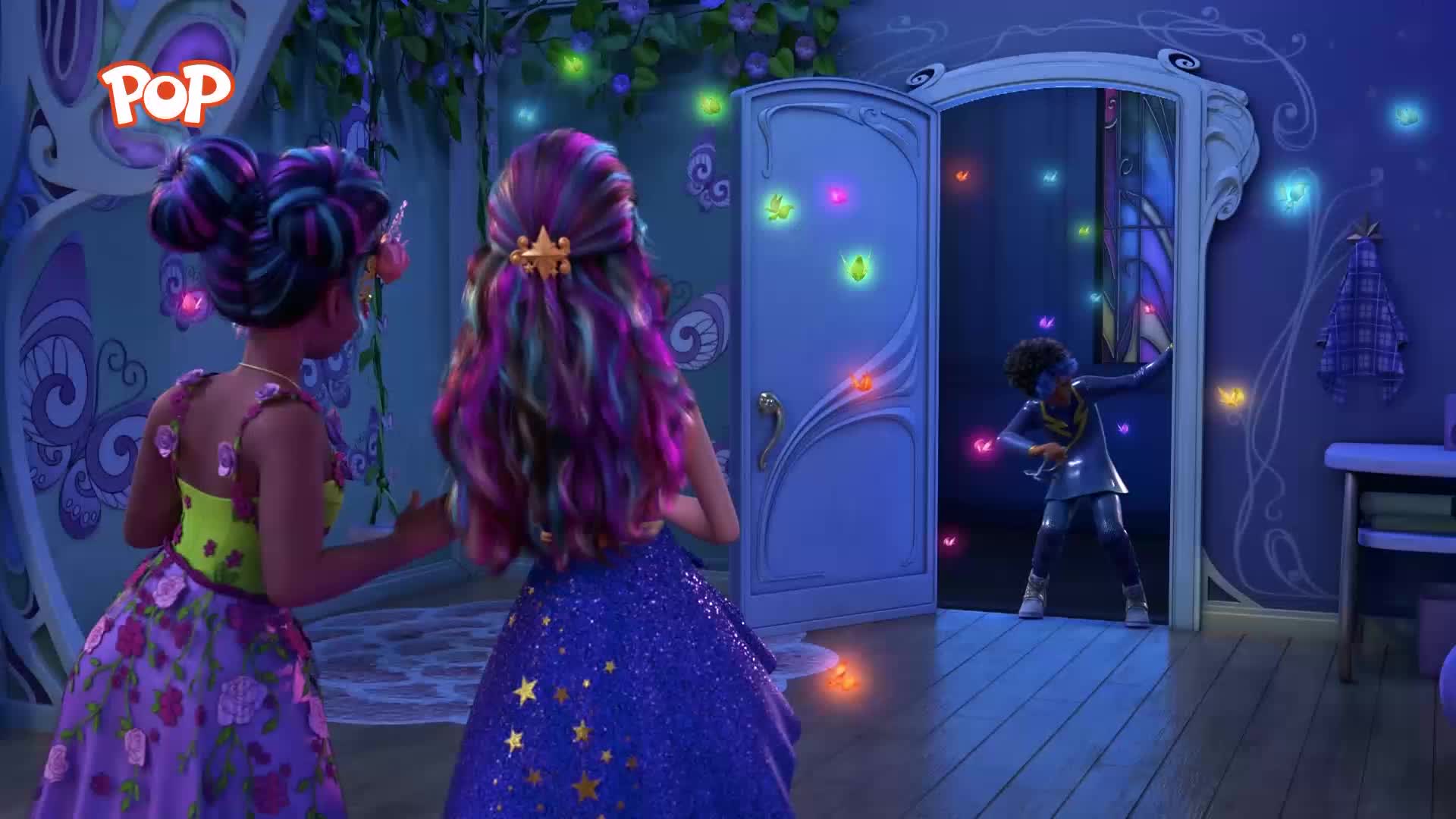 A young person in a silver outfit stands in a doorway, reaching out towards the glowing, colourful lights that fill the room. Two girls with vibrant, multi-coloured hair watch from the side, their elaborate dresses shimmering.