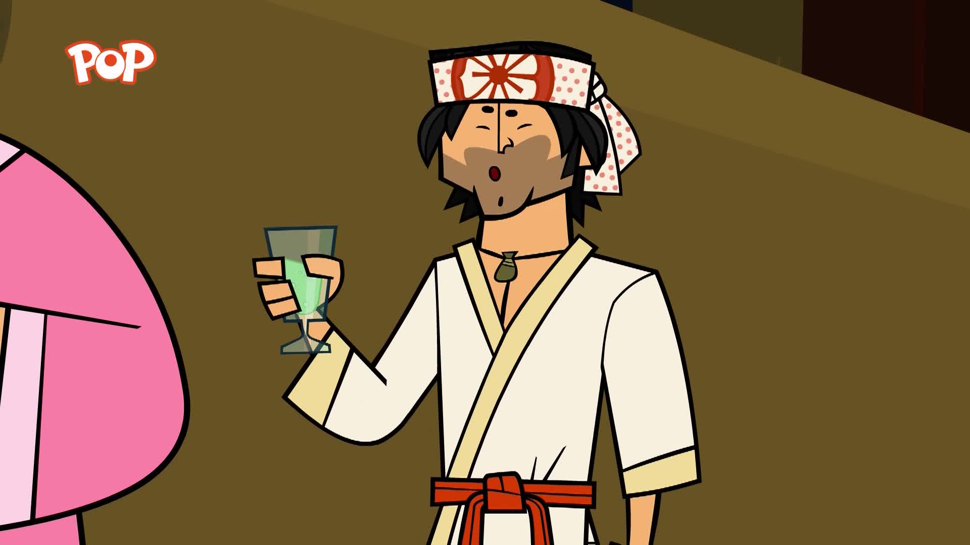 A man in a white robe and headband holds up a glass of green liquid. He's got a surprised look on his face. A man in a white robe and headband holds up a glass of green liquid. He's got a surprised look on his face.