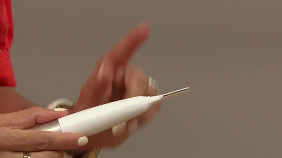 A hand, with a painted nail, holds a white beauty tool and points with a finger. The tool's tip is angled towards the right, reflecting light.

