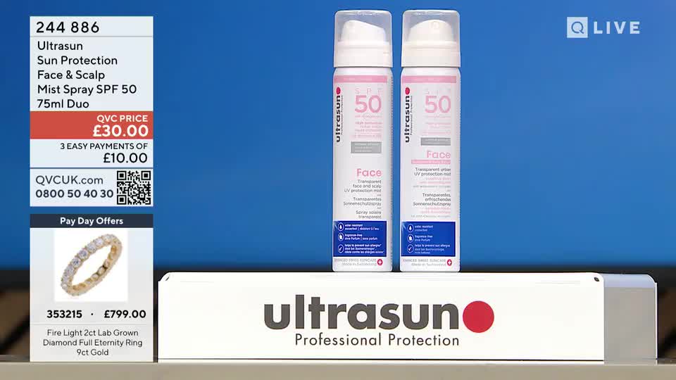 Two cans of Ultrasun SPF 50 mist spray stand side-by-side on a white platform. Below them, a diamond eternity ring is displayed, its stones catching the light.
