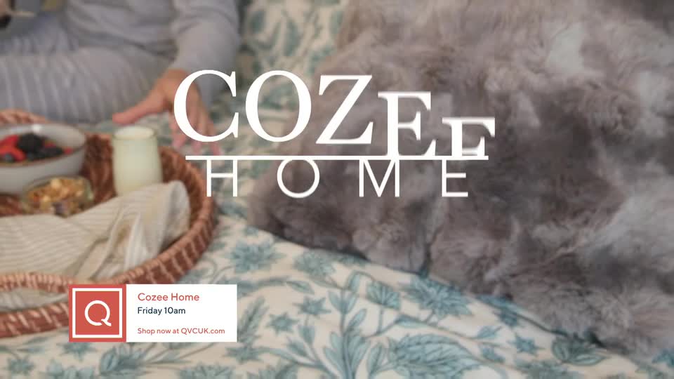 A fluffy grey blanket covers most of the bed. A wicker tray with breakfast sits to the left, and the words "COZEE HOME" are overlaid.