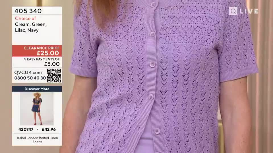 A woman in a lilac cardigan is centered, the knit fabric detailed with a diamond pattern. The QVC Extra screen in the United Kingdom displays the clearance price of the cardigan.
